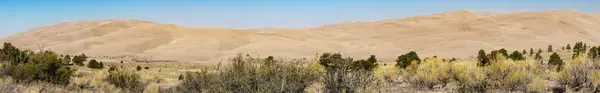 Great Sand Dunes wide panorama with prairie scrub foreground, Colorado